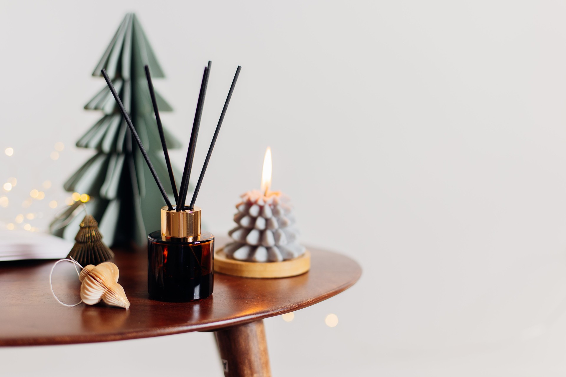Home aroma fragrance diffuser and burning candles on wooden table in the bedroom. Interior elements. Christmas and Winter decoration